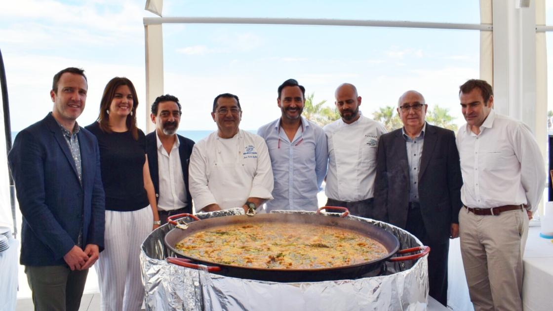 representantes del evento delante de una paella